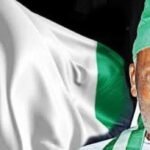 Michael Taiwo Akinkunmi alongside the Nigerian flag